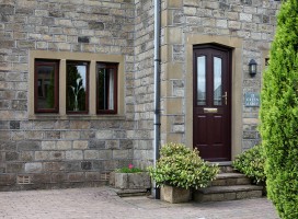 Shaped Harlech composite door in Rosewood with Prairie glass.